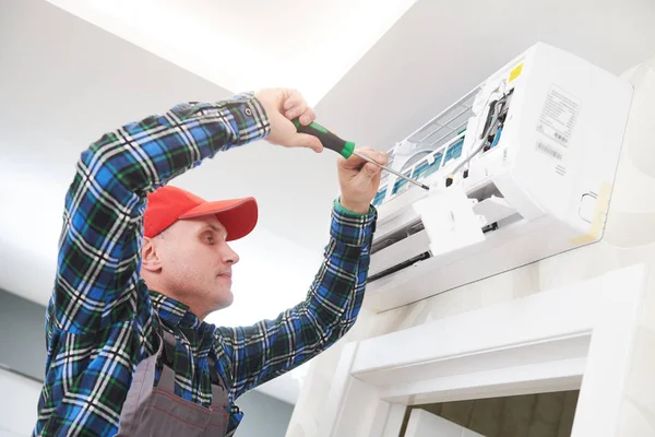 Servicio de aire acondicionado. Trabajador en instalación de sistemas de climatización en interiores — Foto de Stock