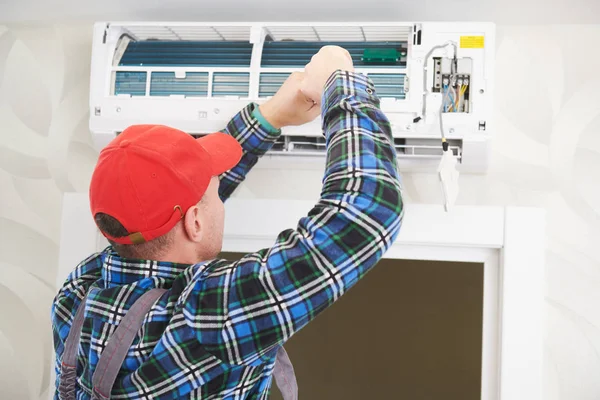 Servicio de aire acondicionado. Trabajador en instalación de sistemas de climatización en interiores — Foto de Stock