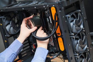 Bilgisayar montaj servisi. Servis elemanı işlemciye sıvı soğutma sistemi yüklüyor