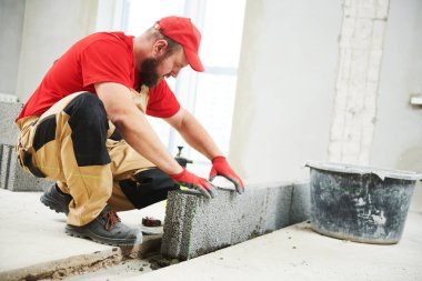 Seramoni beton bloklarıyla çalışan tuğla ustası. Duvarlama