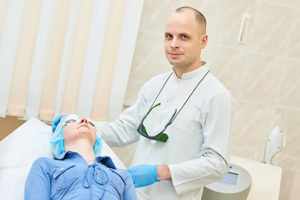 Procedimiento facial de belleza. Retrato médico masculino con paciente —  Fotos de Stock