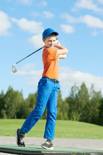 Мальчик играет в гольф летом — стоковое фото