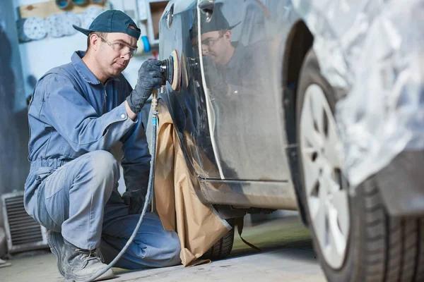 Auto reparateur slijpen autocarrosserie motorkap — Stockfoto