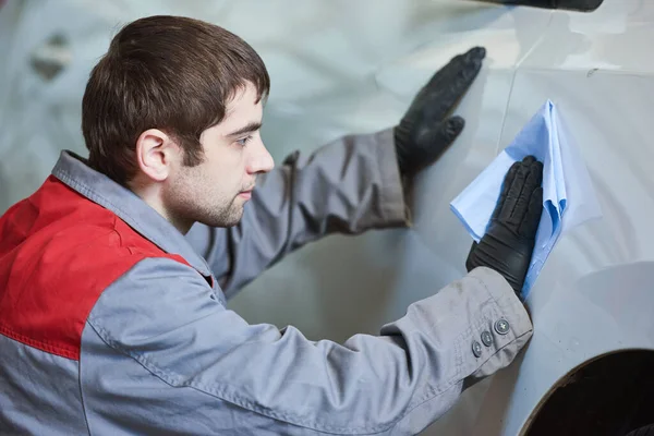 Reparación hombre trabajador limpieza coche carrocería en el garaje — Foto de Stock