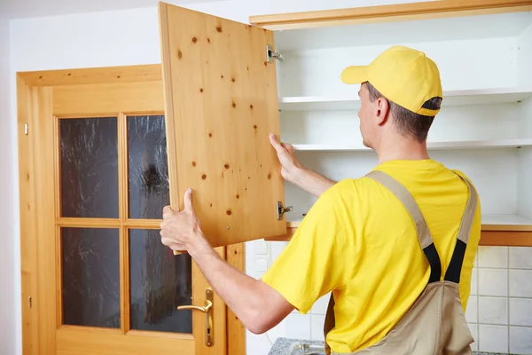 Trabajador instalando armario de cocina — Foto de Stock