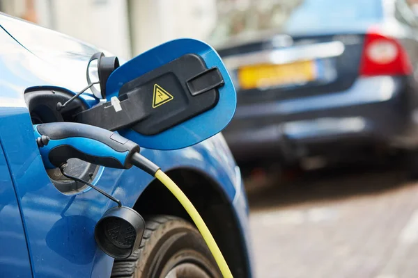 Fonte de alimentação conectada a um carro elétrico durante o carregamento — Fotografia de Stock