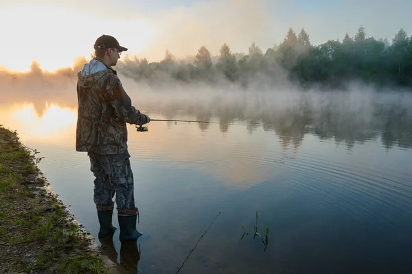 Fisher fishing on foggy sunrise — Stock Photo, Image