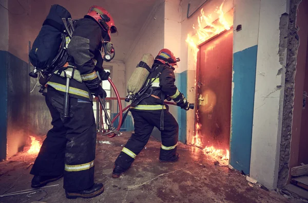 Equipo de bomberos durante la lucha contra incendios —  Fotos de Stock