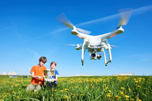 Kinderen die vliegen met een drone bij zonsondergang — Stockfoto