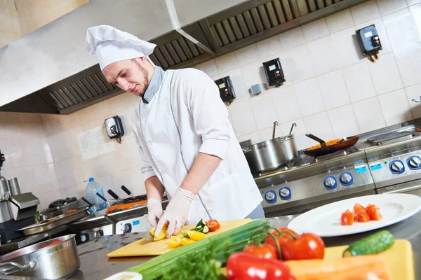 Mannelijke chef-kok snijden groenten voor salade voedsel — Stockfoto