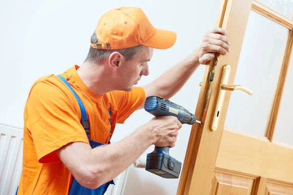 Carpenter at door lock installation or repair — Stock Photo, Image