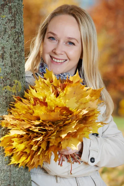 Mulher com folhas de bordo no outono — Fotografia de Stock