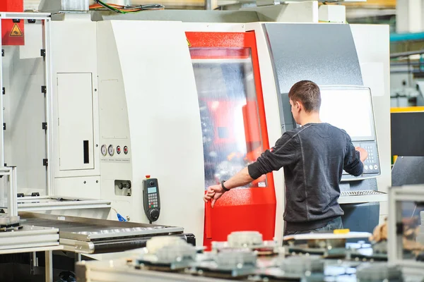 Trabalhador industrial operando máquina cnc na indústria de usinagem de metal — Fotografia de Stock