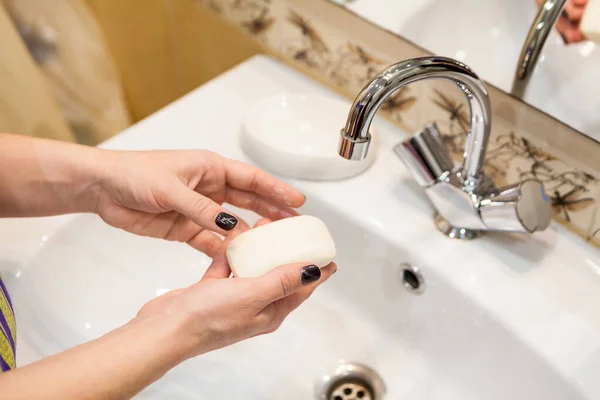 Person takes soap from soap-dish for hands washing, personal hygiene in home