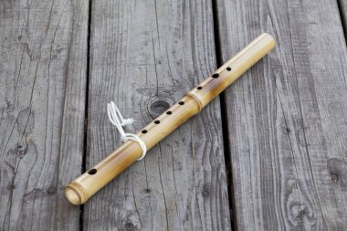 Yedi delikli bambu flüt kare kenarlı zeminde yatıyor, bir nesne.