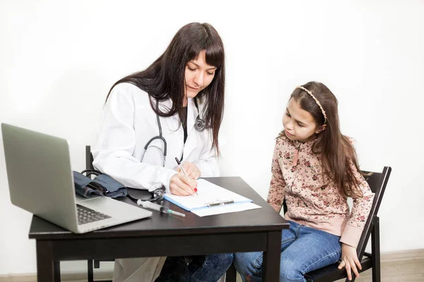 Nastoletnia Biała Dziewczyna Odwiedza Lekarza Pediatrę Pisząc Schowku Podczas Rozmowy — Zdjęcie stockowe