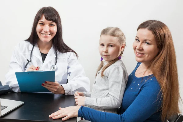 Zufriedene Mutter Mit Kind Beim Kinderarzttermin Blick Die Kamera lizenzfreie Stockfotos