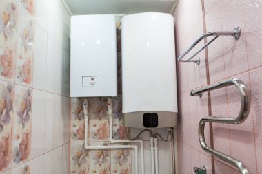 Isı ve sıcak su tedarik sistemleri banyonun duvarında. Merkezi ısıtma için elektrikli kazan ve sıcak su için tank.