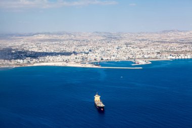 Aerial view at Larnaca city and Main Harbor in the Cyprus island. Dry-cargo freighter coming from port clipart