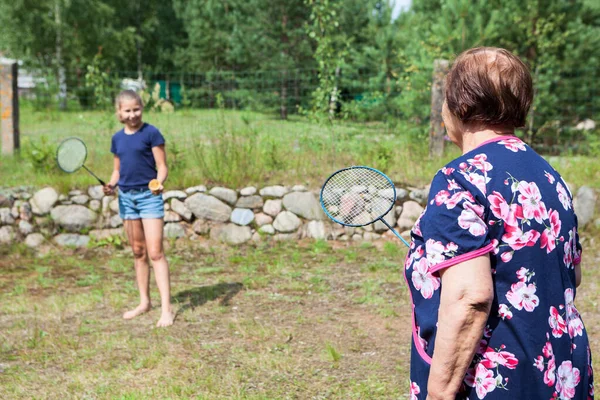 Oudere Grootmoeder Probeert Badminton Spelen Met Haar Jonge Kleindochter Buiten — Stockfoto