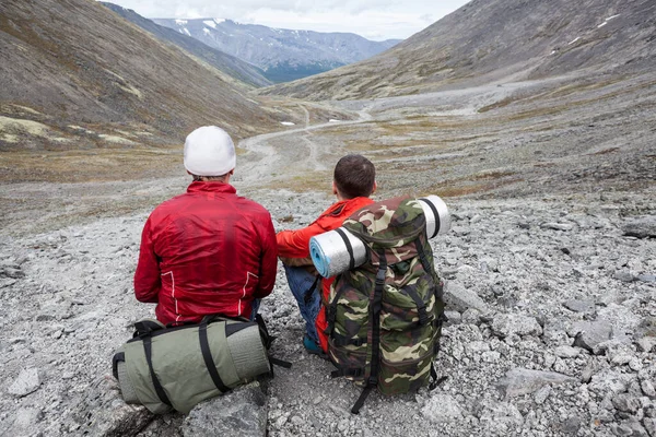 Deux Routards Assis Sur Des Pierres Regardant Loin Seul Chemin Photo De Stock