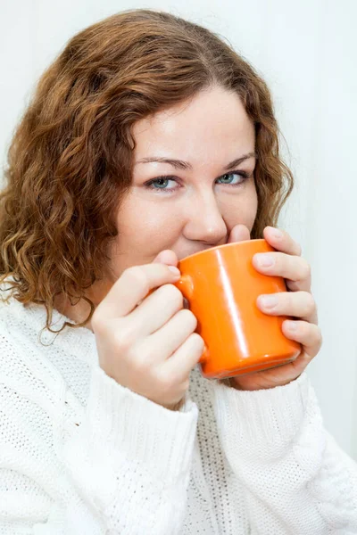 魅力的な女性の笑いとコーヒーを飲んで 白いセーター カメラを見ると — ストック写真