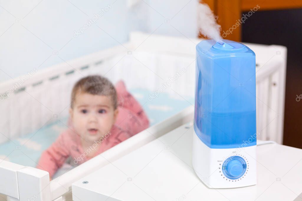 Newborn kid healthcare with using ultrasonic humidifier, device standing next to cot