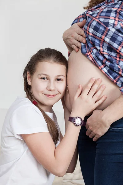 Jovencita Alegre Abrazando Madre Embarazada Barriga Escuchando Mirando Cámara Sonriendo —  Fotos de Stock