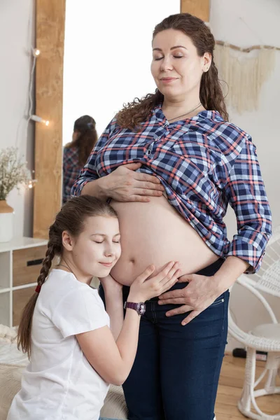 Chica Joven Tranquila Tocando Vientre Madre Embarazada Con Oído Escuchando —  Fotos de Stock
