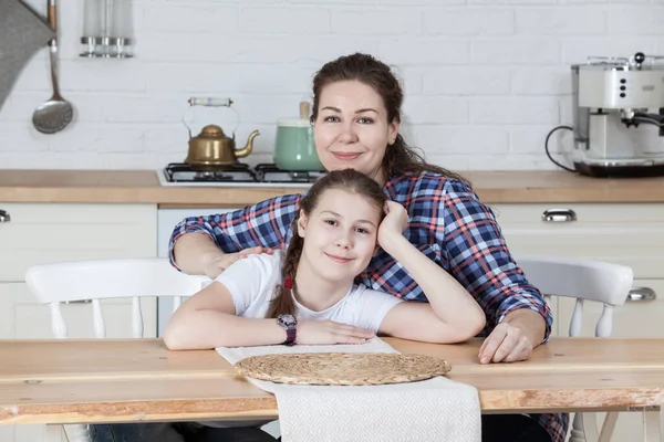 Madre Con Hija Adolescente Sonriente Sentada Mesa Cocina Juntos Mirando —  Fotos de Stock