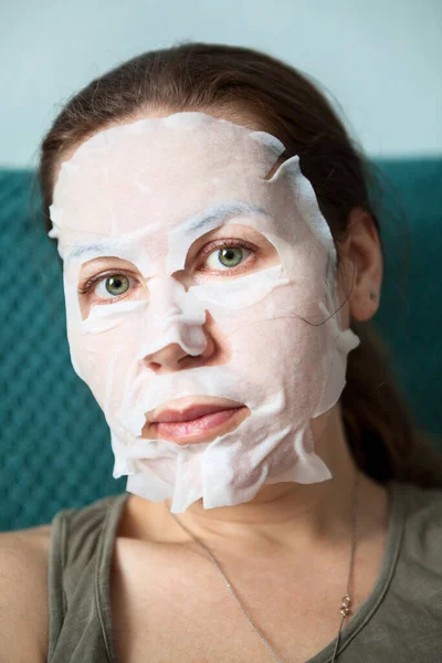 Facial mask using for cosmetology, beauty therapy. Close up of female face and skin