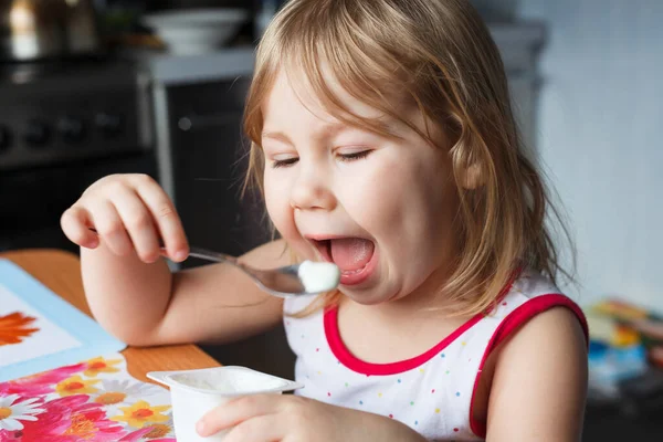 Little Caucasian Girl Eating Yogurt Herself Spoon Sitting Table Kitchen — Stock Photo, Image