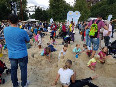 Ebeveynler ve kumla oynayan çocuklar