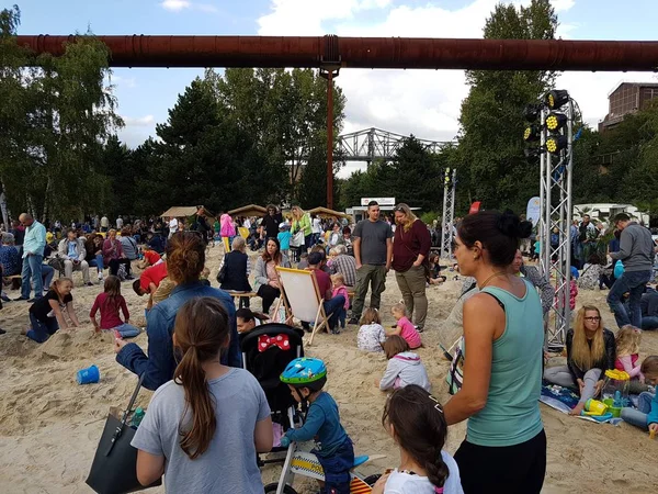 Ebeveynler ve kumla oynayan çocuklar