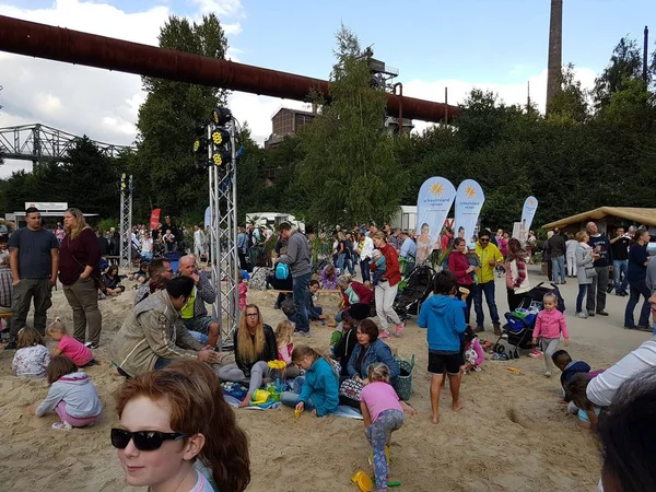 Ebeveynler ve kumla oynayan çocuklar