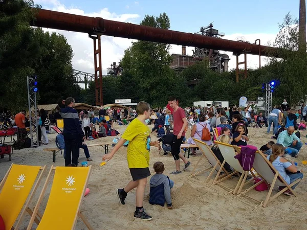 Ebeveynler ve kumla oynayan çocuklar