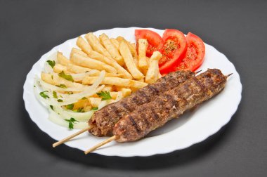 Gri zemin üzerinde yiyecek olan beyaz seramik tabak