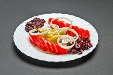 Salamura zeytin, domates, biber, soğan, feta peyniri, zeytinyağı ve baharat karışımlı beyaz seramik tabaklar.