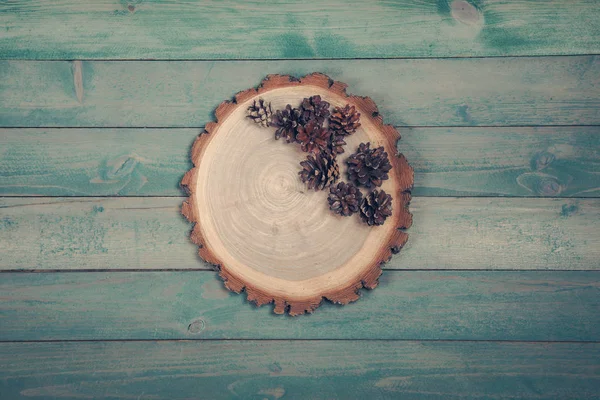 Дерев'яна дошка з сухими сосновими шишками на дерев'яному столі — стокове фото