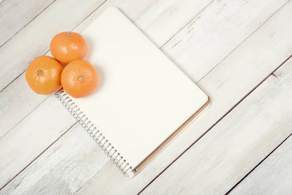 Tangerine (Mandarijn) met lege notebook — Stockfoto