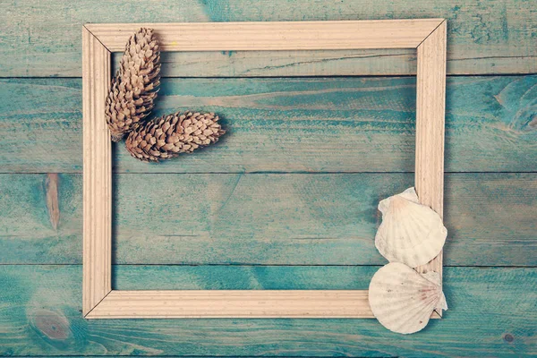 Photo frame with two pine cones and sea shells