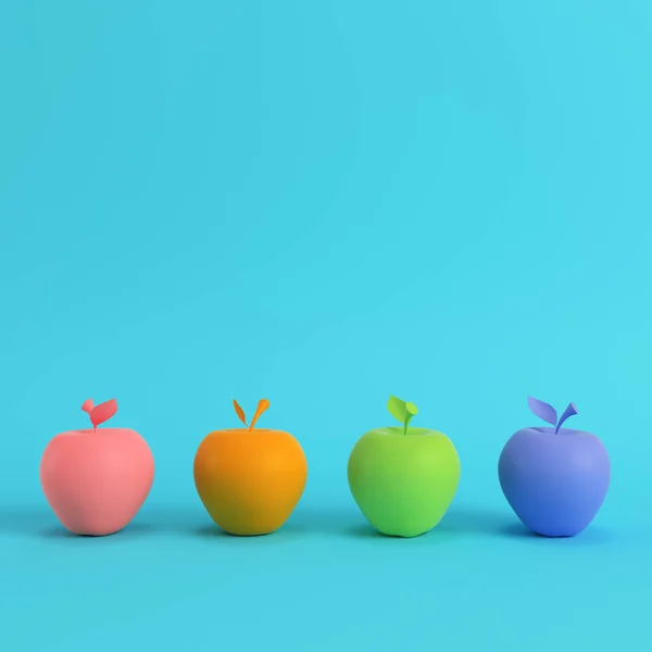 パステル カラーの明るい青色の背景にカラフルなりんごを 4 つ — ストック写真