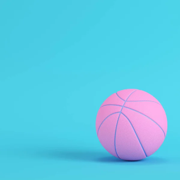 Pink basketball ball on bright blue background in pastel colors.