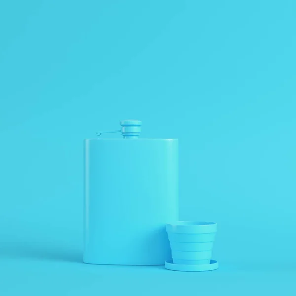 Тазобедренная фляжка с чашкой на ярко-голубом фоне в пастельных тонах. M — стоковое фото
