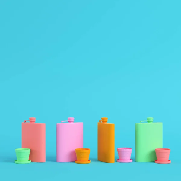 Four hip colorful flasks with cup on bright blue background in p — 스톡 사진