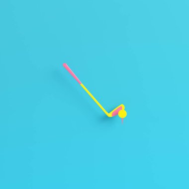 Sarı golf sopası, parlak mavi arka planda golf topu, pastel renklerde. Minimalizm kavramı. 3d hazırlayıcı