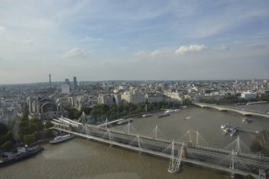 Thames Nehri üzerinden Embankment İstasyonu 'na uzanan Hungerford ve Golden Jubilee köprülerinin manzarası. Arka planda Victoria Embankment Gardens ve Waterloo Köprüsü var. Londra Gözü 'nden alındı..