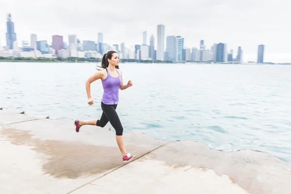 Frau joggt mit Chicago Skyline im Hintergrund, Schwenk — Stockfoto