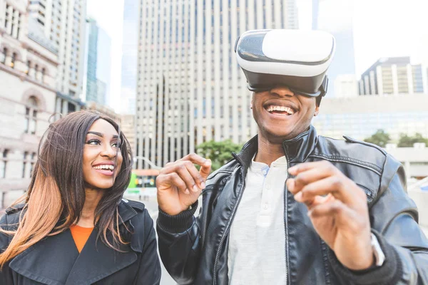 Mujer y hombre sonriendo mientras intenta auriculares de realidad virtual —  Fotos de Stock