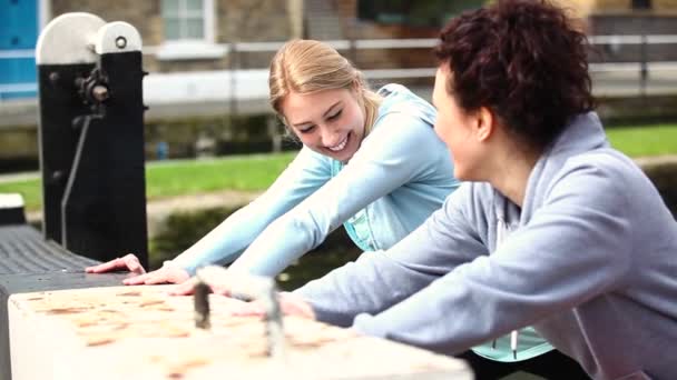 Dvě holky dělají protahovací cvičení venku v Londýně — Stock video